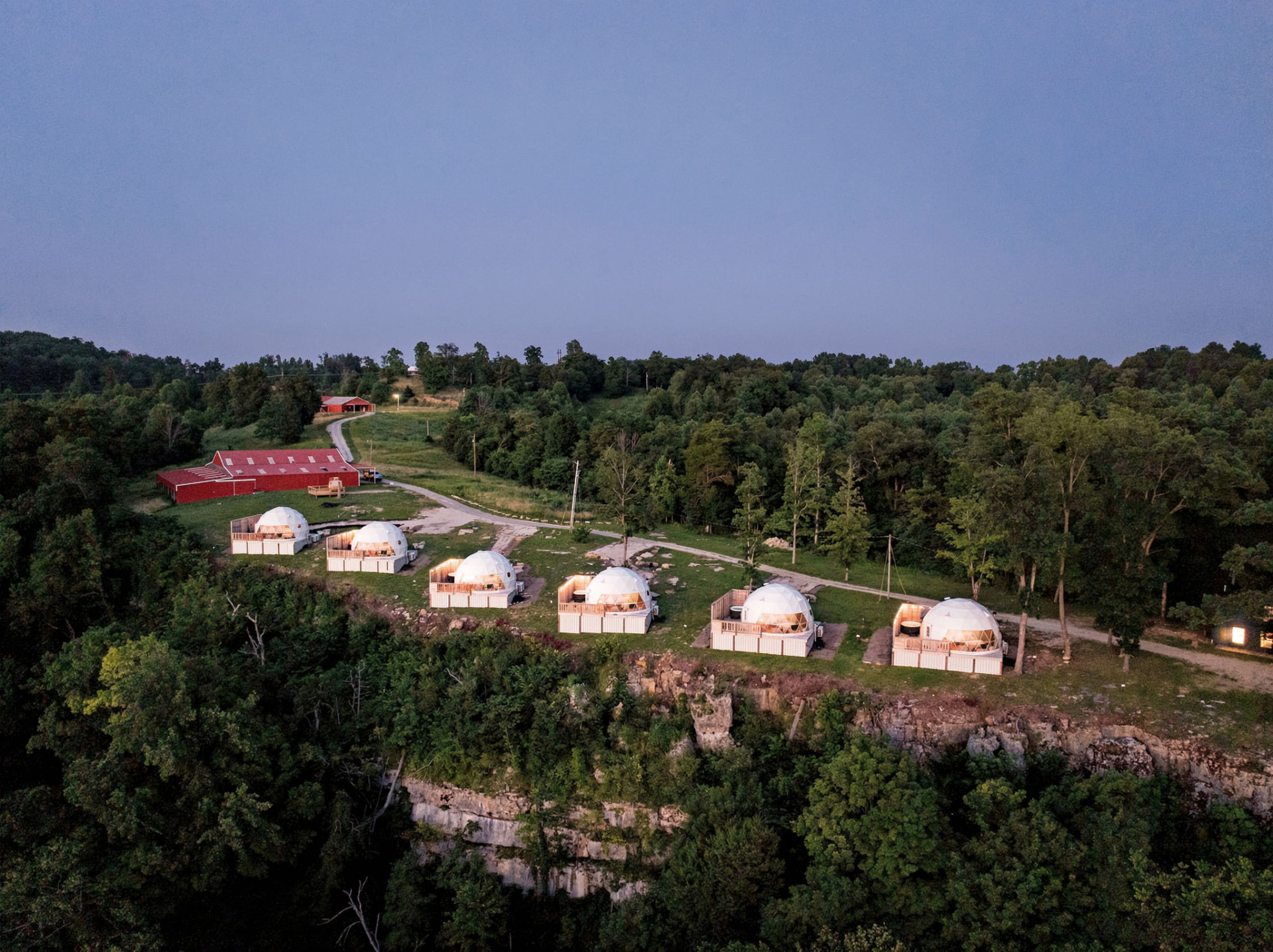 Dusk aerial view of the lit domes perched along the clifftop at The Overlook